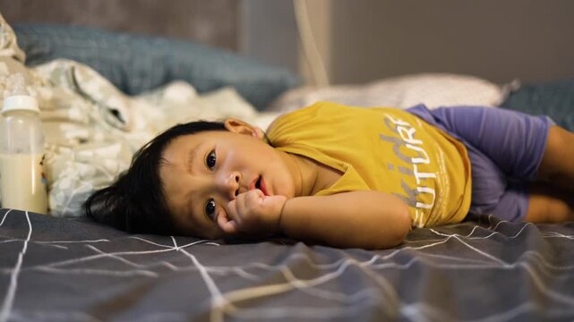 Toddler Lying Down Exploring Emerging Teeth, A charming and relatable video of a toddler playfully feeling new teeth, suitable for baby care, creative storytelling and development documentary.