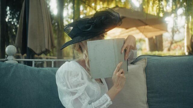 Woman Reading Outdoors. Charming Woman In Stylish Attire Reading Book With Playful Gestures In Sunlight