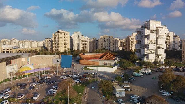 Holon urban scenery with the Mediatheque complex and residential neighborhoods during a push in and rising flight, Israel.