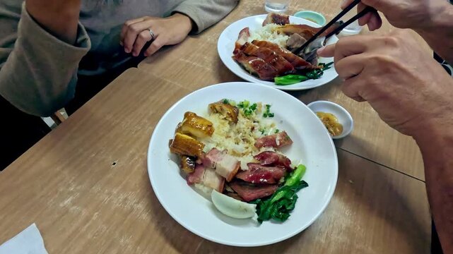 Hyperlapse of sharing a meal of roasted goose and chicken (Si Yip and Siu Gai), pork belly (Siu Yuk) and rice. Authentic traditional local Cantonese food in Hong Kong