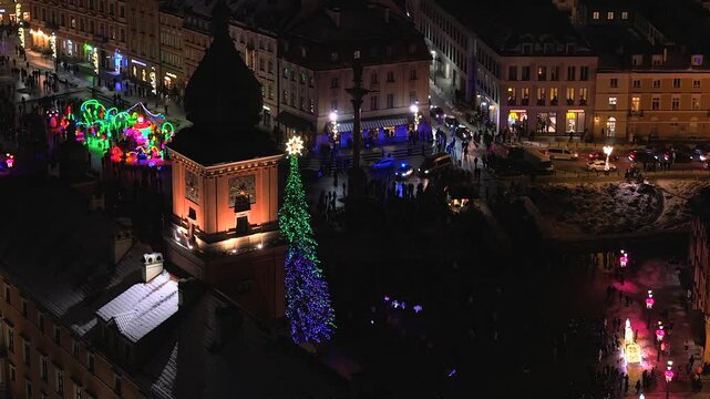 Festive aerial perspective of warsaw's royal castle and castle square, decorated with a large christmas tree and colorful lights