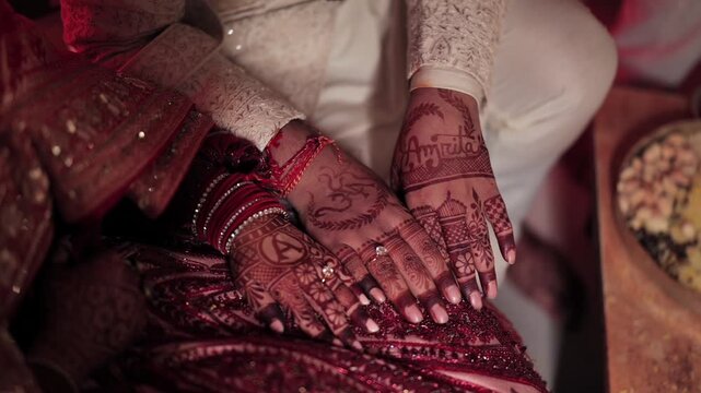 An Indian bride and groom showing mehndi hands with ther wedding rings close up