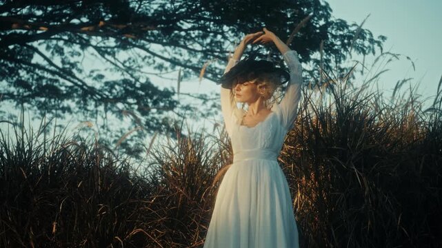 Woman In Field. Nostalgic Scene With Woman In Flowing White Dress Amid Tall Golden Grass At Sundown