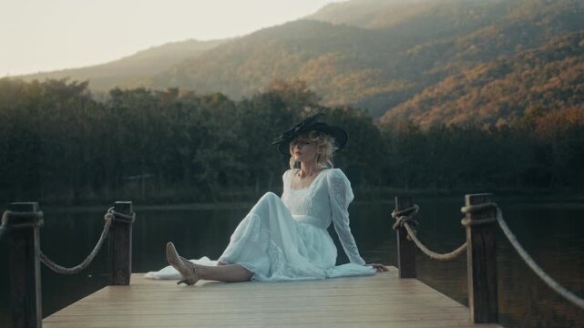 Woman In Dress Near Tranquil Water. Gentle Dusk Glow Illuminates Tranquil Lakeside With Peaceful Lady