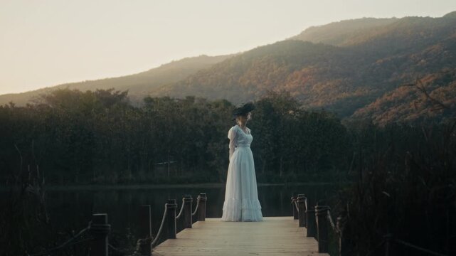 Woman In Dress Near Tranquil Water. Gentle Dusk Glow Illuminates Tranquil Lakeside With Peaceful Lady