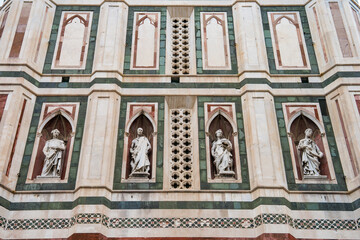 Obraz premium Close-up details of Florence Cathedral's exterior facade (Cattedrale di Santa Maria del Fiore), showcasing intricate marble and Gothic design. Florence,Italy 03.01.2026 