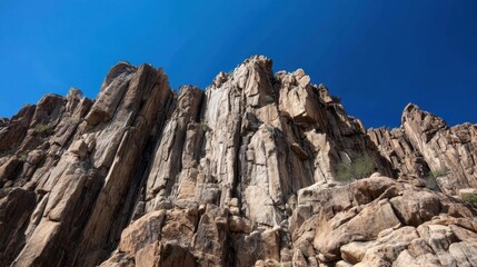 Dramatic Rocky Cliffs Against Clear Blue Sky Showcasing Natural Landscape Beauty and Geological Features in Bright Daylight
