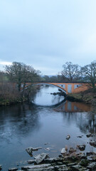 Stanley Bridge. The orange bridge against the backdrop of a cloudy sky and stone boulders
