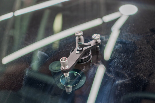 Windshield repair. Repair of a chip on the windshield of a car. Mounted windshield repair bridge holds resin applicators securely over the crack. Bridge tool for injecting resin in damaged windshield.