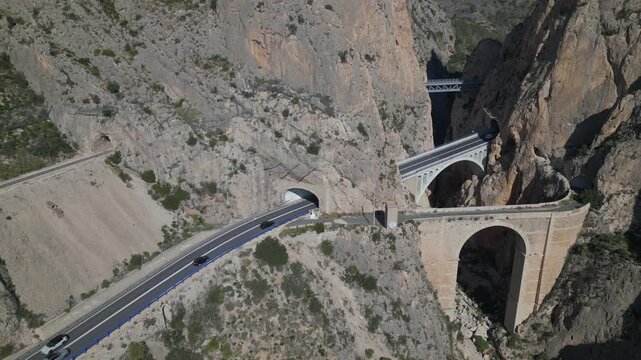 Aerial view of cars driving through mountain tunnels and bridges