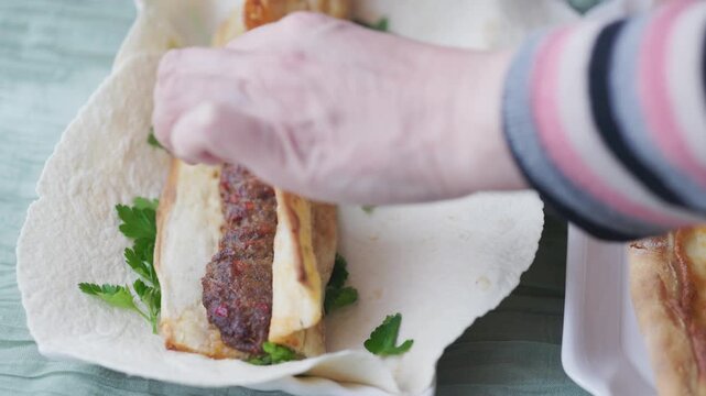 Close-Up of Traditional Adana Kebab with Lavash and Greens