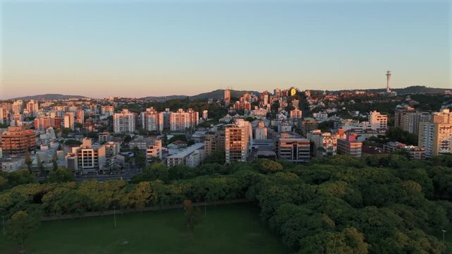 Lateral parallax over Parque Marinha reveals Menino Deus neighborhood skyline at sunset in Porto Alegre. Captured in D-Log with 10-bit color using a Hasselblad sensor.