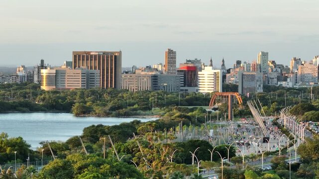 Telephoto lateral pan along Guaiba waterfront shows Usina do Gasometro tower and Porto Alegre skyline at sunset, 4K50.