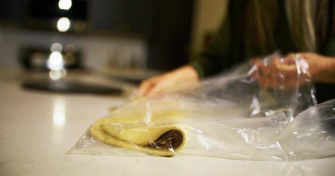 Woman's hands taking flattened pizza dough and turning it into a ball - closeup, handheld shot 