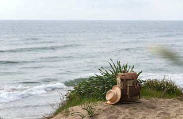 Naklejka premium Dune with backpack and straw hat next to blurred sea