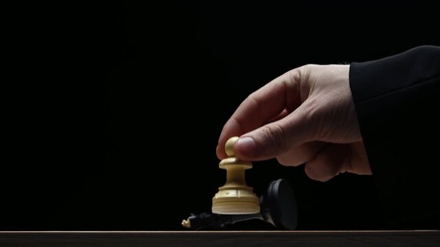 A pawn kills a king on a black background. Chess competition view of the board from below. Checkmate to the king from a pawn