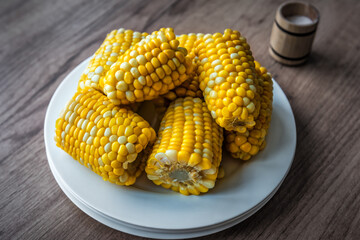 Delicious boiled corn cobs on the plate