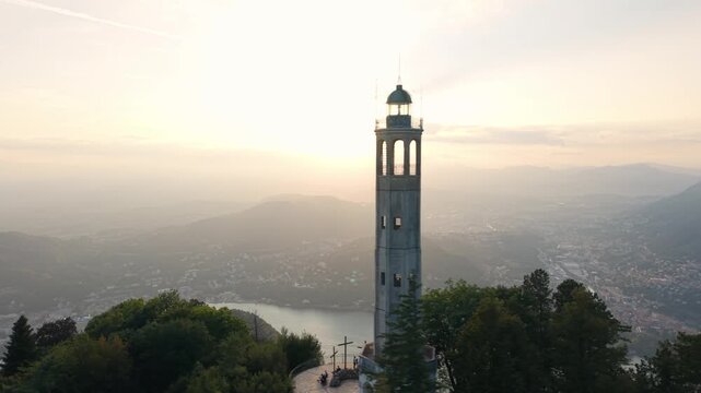 Faro Voltiano lighthouse standing tall on Brunate hill with a radiant sunset in the background