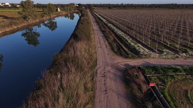 Winter water reservoir beside fruit orchard during seasonal dormancy