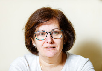 Fototapeta premium Mature caucasian female with glasses and brown hair smiling indoors