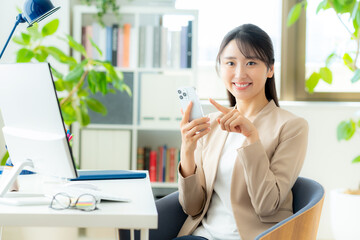オフィスでスマホを使うビジネスウーマン