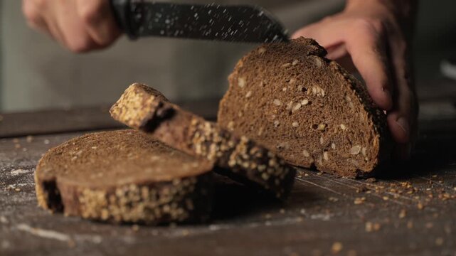 Baker slicing fresh whole grain rye bread with seeds on a rustic wooden cutting board for a healthy breakfast meal