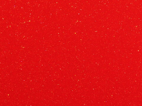 Macro photography of bright red metallic paint texture with fine sparkles