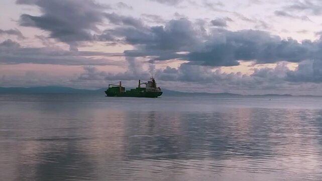 Cinematic View of Cargo Ship Anchored in Biak Bay at Sunset, Papua, Indonesia.
