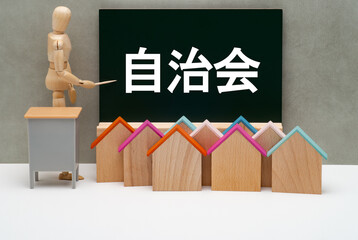 自治会と書かれた黒板とデッサン人形