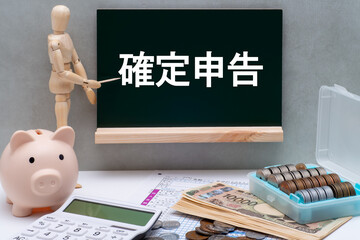 黒板に書かれた確定申告とデッサン人形