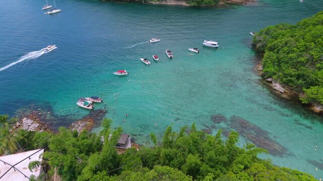 Lagoa Azul on Ilha Grande in Angra dos Reis, Rio de Janeiro, Brazil, showing turquoise shallow Atlantic water with anchored boat and swimmer activity surrounded by Mata Atl&acirc;ntica vegetation, aerial