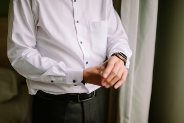 Man in elegant white shirt preparing for a special occasion