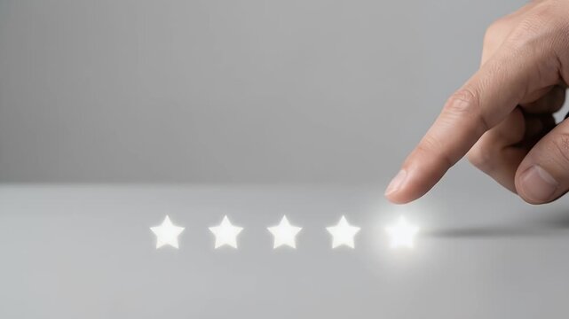 Close-up of a persons finger touching the fifth glowing white star in a row, the star pulses with bright light upon contact against a neutral grey background, static framing with soft studio lighting,