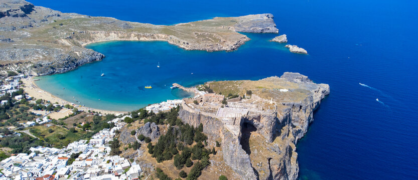 The Acropolis of Lindos in Rhodes island Greece. Saint Paul's Beach and Lindos Acropolis aerial panoramic view.