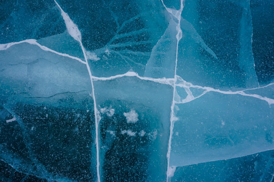 Texture of ice with cracks on a frozen river