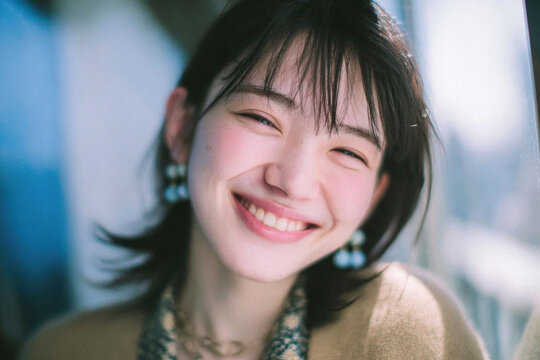Joyful Young Asian Woman Smiling Brightly in Sunlight