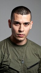 Obraz premium Portrait of a young man with short dark hair, wearing an olive green shirt