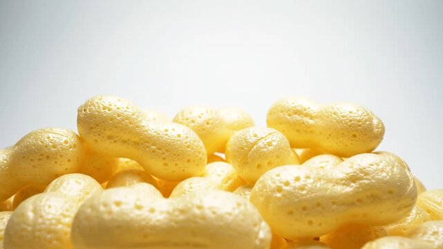Heap of light yellow crunchy corn snack puffs