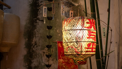 Naklejka premium Antique Lanterns Hang Beside Bamboo Grove