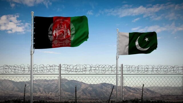Afghanistan and Pakistan national flags flying above the barbed wire border fence