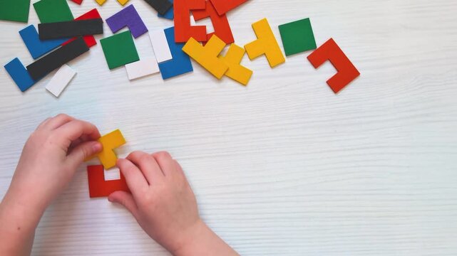 Top view video of children&rsquo;s hands arranging wooden puzzle Colorful geometric shapes in specific sequence Educational activity developing logic, pattern recognition, spatial thinking fine motor skills