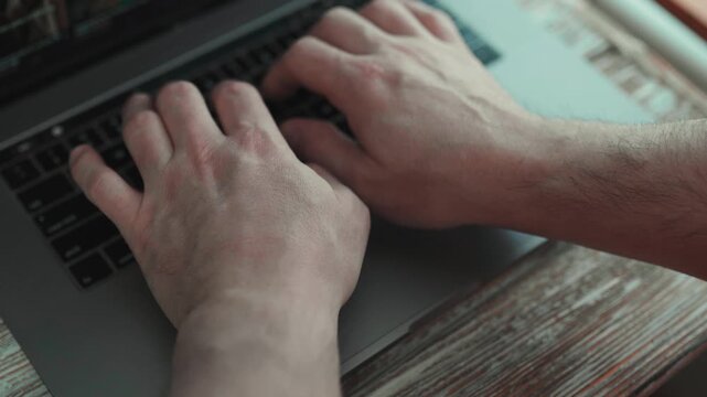  Hands typing on laptop keyboard on clean white desk.