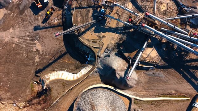 Aerial view of conveyor belts and stone piles. Symmetrical arrangement of industrial conveyors transporting crushed rock to various stockpiles at a quarry.