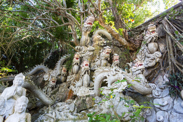 Outdoor shrine with an elaborate carving of mythical figures and guardians nestled in the dense foliage of the Marble Mountains