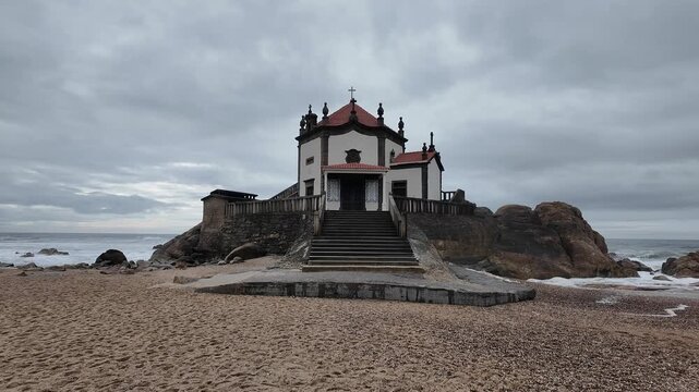 Cinematic View of Capela do Senhor da Pedra on Atlantic Ocean Coast &ndash; Historic Seaside Chapel in Porto, Portugal Under Dramatic Cloudy Sky