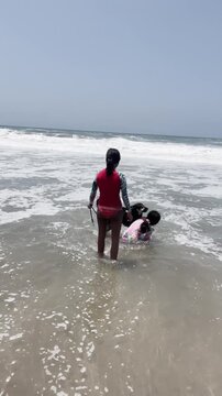 Father selfie POV with kids and dog playing in beach waves