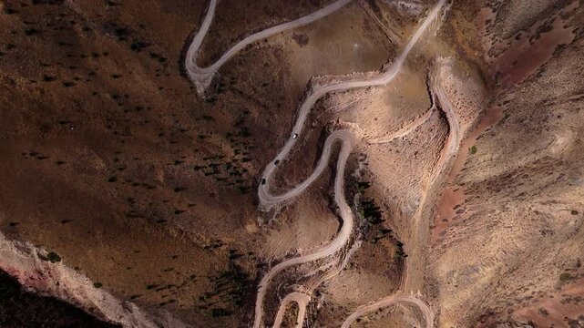 Winding Dirt Road Switchbacks with Cars in Mountains Aerial View