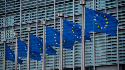 European union flags in front of modern building facade