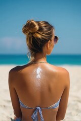 Naklejka premium Young caucasian female relaxing on sunny beach with sunscreen