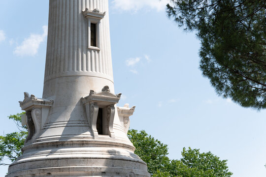 Marble monument column base with decorative capitals and trees